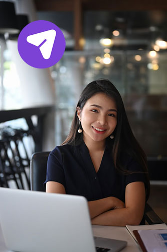 An Asian woman sitting at a desk at her workplace