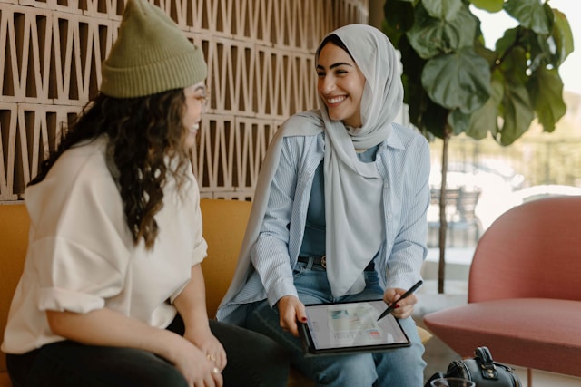 Two women discussing work over a tablet